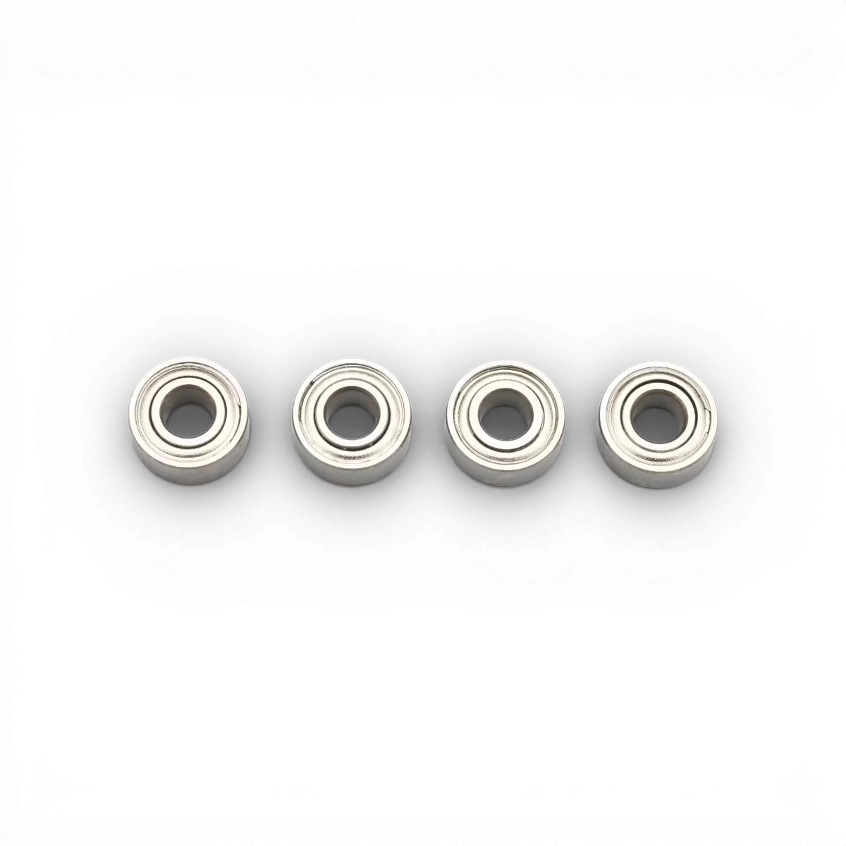Quatre roulements de 3x7x3 mm de la marque Team Yokomo, pièces détachées pour modélisme ou robotique, visibles en image.