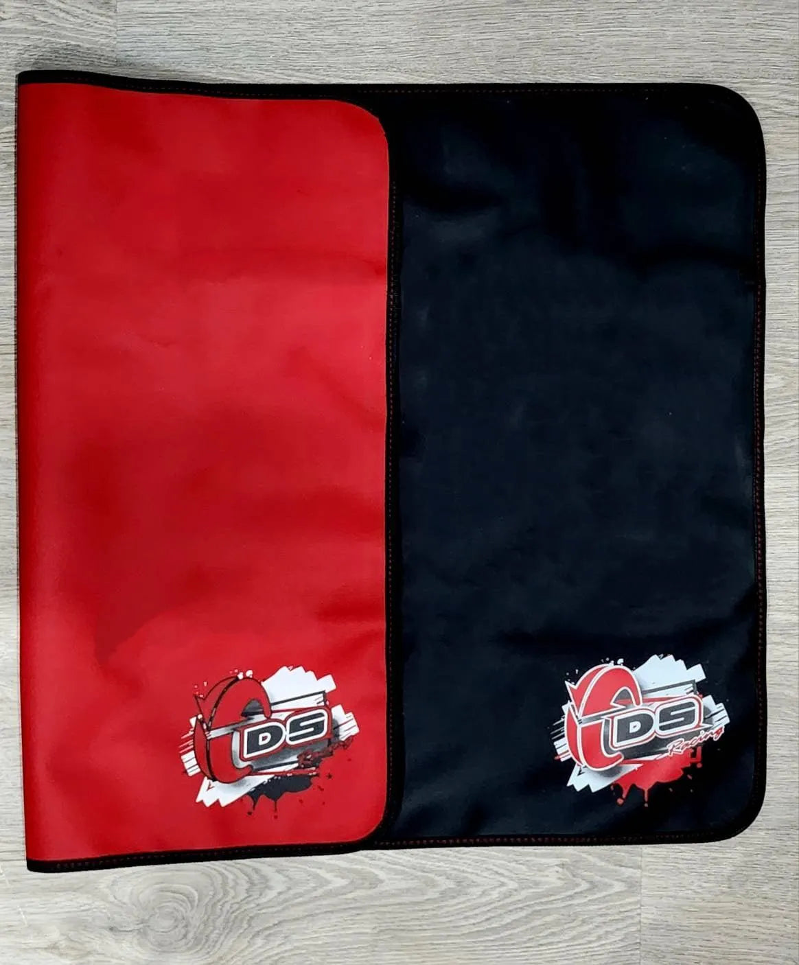 Tapis stand double face DS Racing, accessoire pour équipements, avec design double face visible sur le tapis.