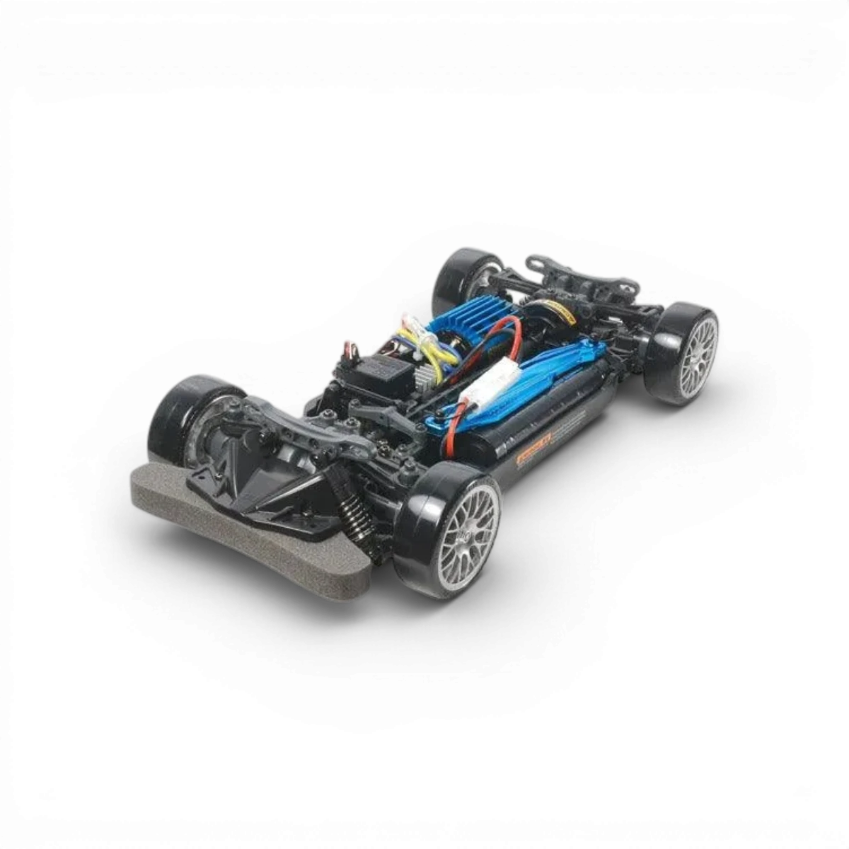 Kit de voiture téléguidée Tamiya Nissan GT-R Drift Spec TT-02D, vue de face avec détails du châssis et des roues.